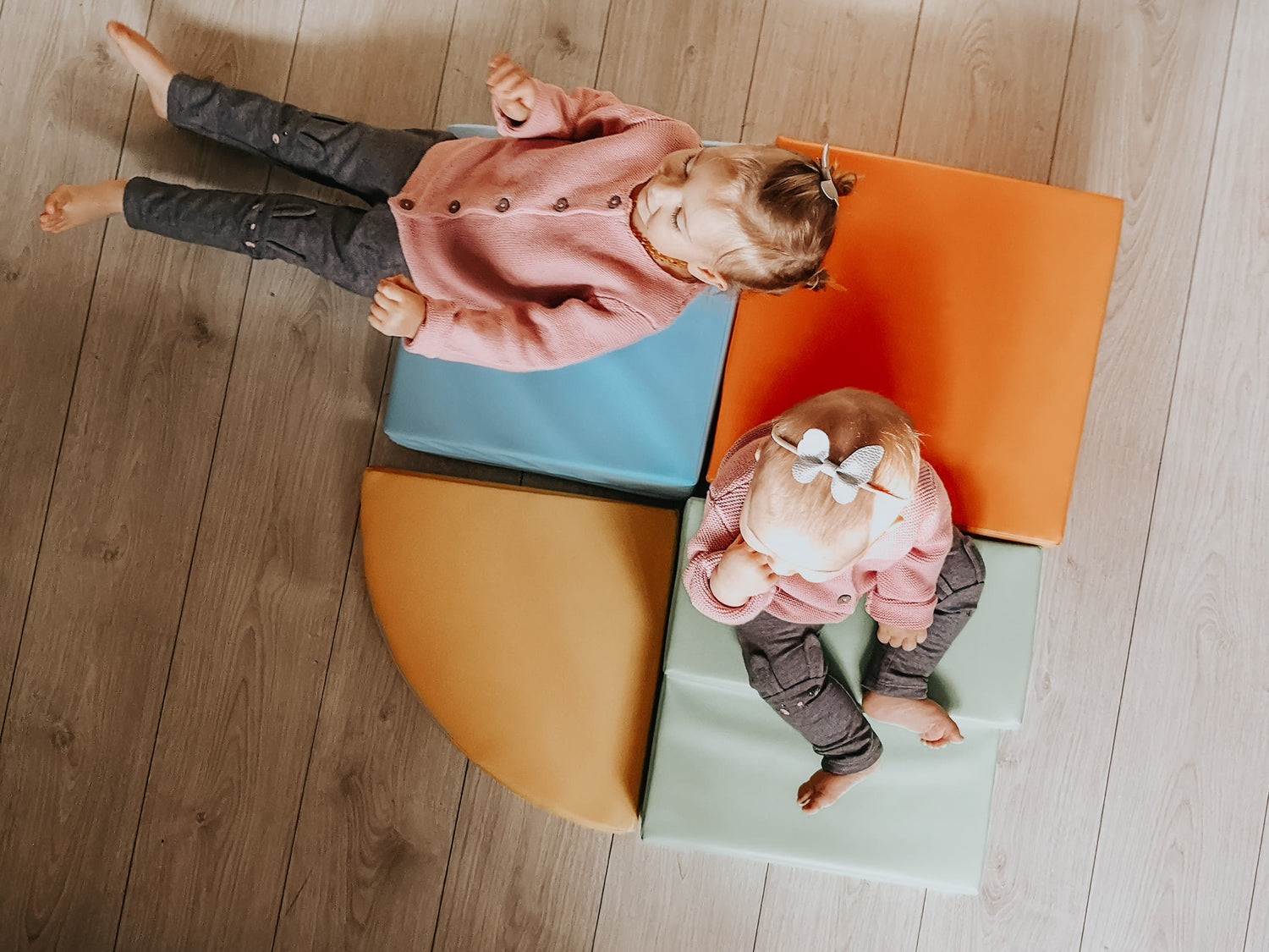Two girls sitting on a colorful IGLU soft play foam set
