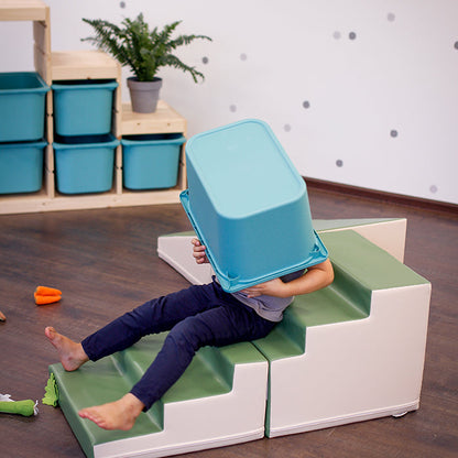 A child is engaging in imaginative play on a 4 Piece Soft Play Step and Slide Set - Transformer by IGLU Soft Play, promoting gross motor skill development.