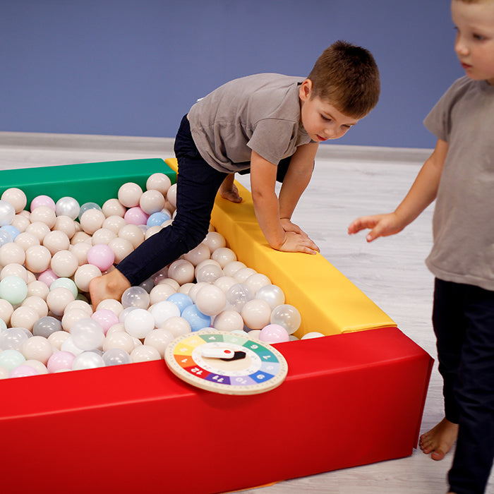 Twin boys playing in a colorful foam ball pit