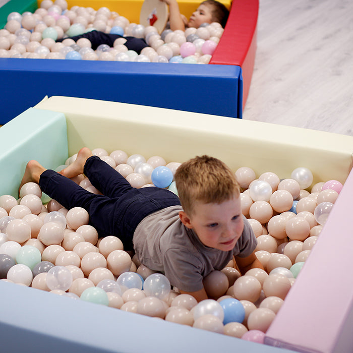 A boy playing in a pastel color IGLU ball pit foam pool