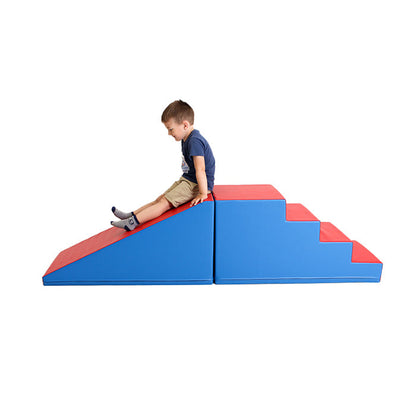 A young boy having fun on a blue and red Soft Play Step and Slide Set - Mega Fun Slider by IGLU Soft Play.