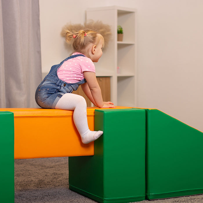 A little girl playing on a Soft Play Activity Set - Balance Bridge on a green and orange play structure made by IGLU Soft Play.