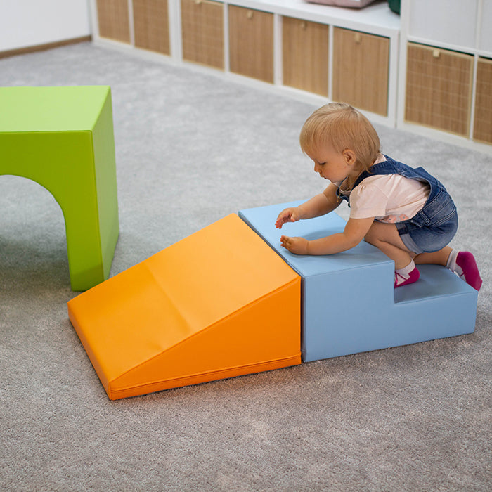 A baby is having fun playing with the Soft Play Set - Mini Tunnel Climber by IGLU Soft Play, promoting physical development.