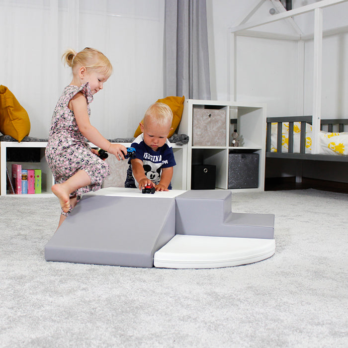 Two children are playing on an IGLU Soft Play Montessori-inspired grey play mat in a room, the Soft Play Set - Corner Crawler.