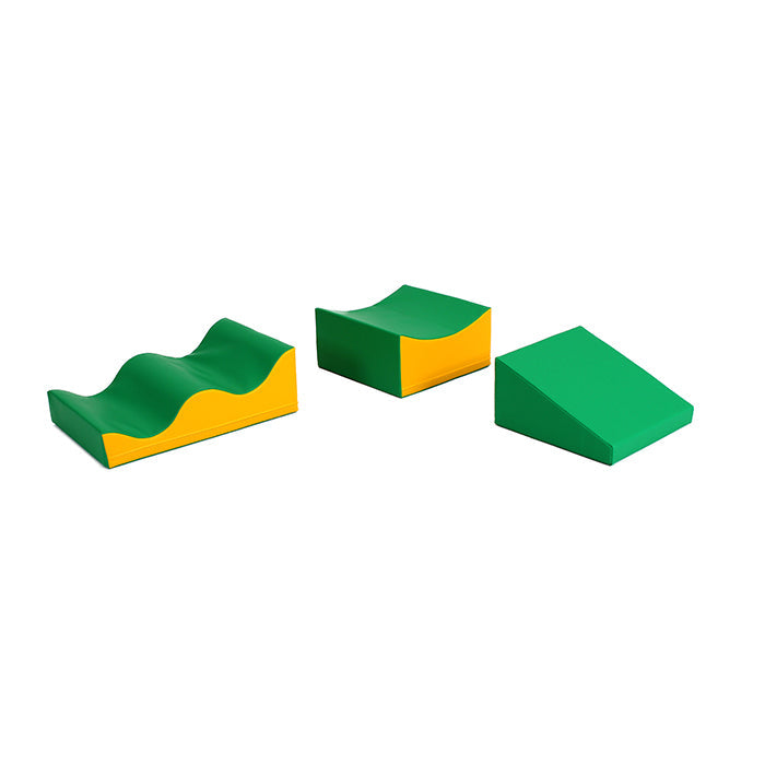 An IGLU Soft Play set of green and yellow foam blocks arranged in Soft Play waves on a white surface.