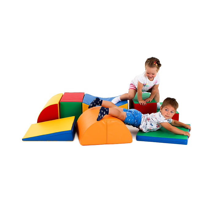 Two children improving their coordination and gross motor skills while playing on a set of colorful foam blocks from the Soft Play Activity Set - Adventurer XL by IGLU Soft Play.