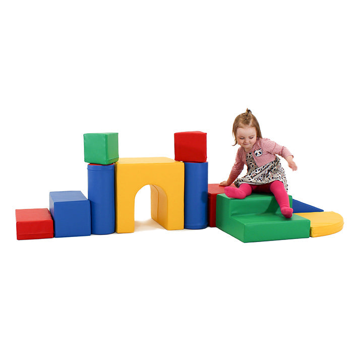 A little girl is playing with an IGLU Soft Play - Castle on a white background.