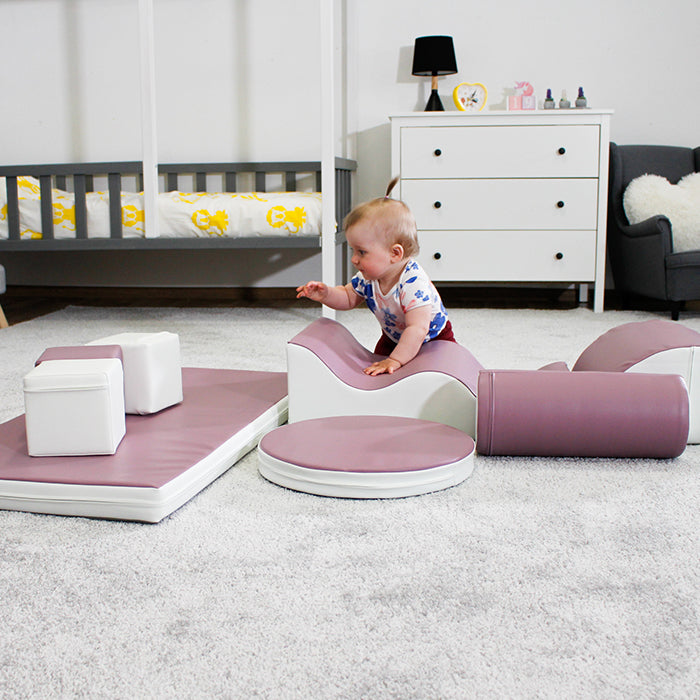 A baby is playing with an IGLU Soft Play Shapes play set in a room.