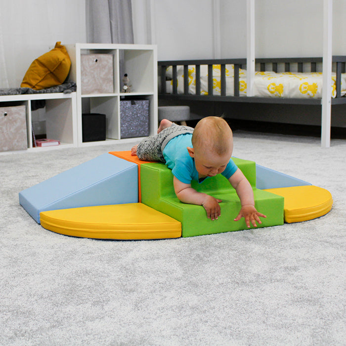 A baby crawls around the room while playing with the IGLU Soft Play - Soft Play Set - Two Way Crawler.